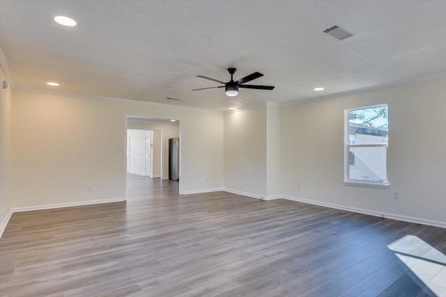 empty room featuring ornamental molding, a textured ceiling, ceiling fan, and light hardwood / wood-style flooring