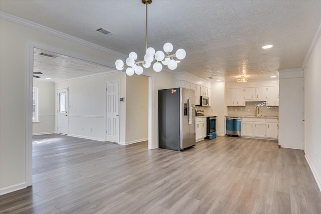 kitchen with sink, white cabinetry, crown molding, hanging light fixtures, and stainless steel appliances