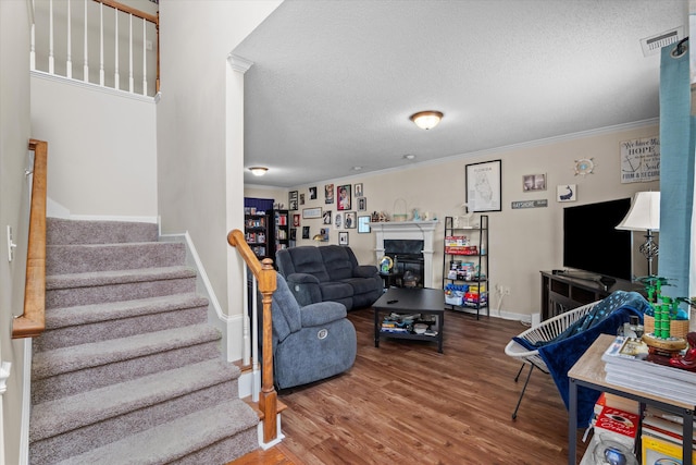 762 Winding Creek Ct, Evans, GA 30809 - living room with stairs, wood finished floors, crown molding, a textured ceiling, and a glass covered fireplace