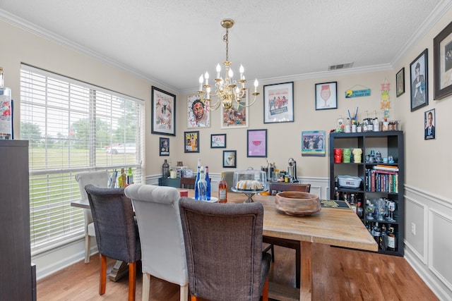 762 Winding Creek Ct, Evans, GA 30809 - dining space featuring a chandelier, crown molding, wood finished floors, a wainscoted wall, and a textured ceiling