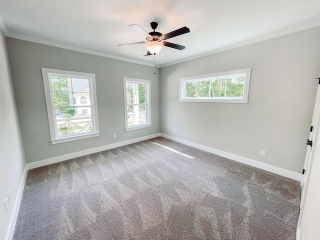 carpeted empty room featuring crown molding, baseboards, and ceiling fan