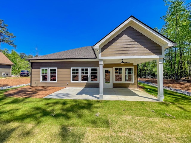 rear view of property with a patio area, a shingled roof, a ceiling fan, and a yard