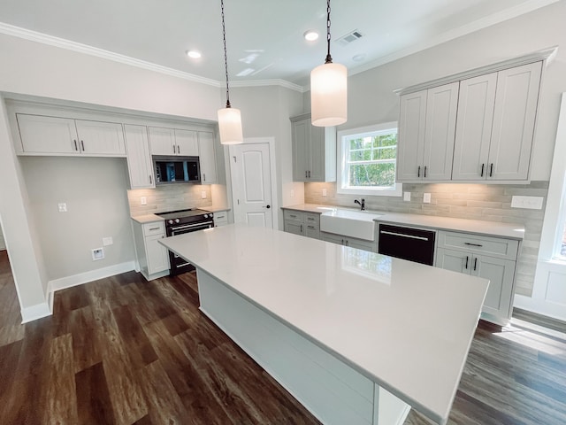 kitchen with a center island, a sink, stainless steel appliances, backsplash, and visible vents