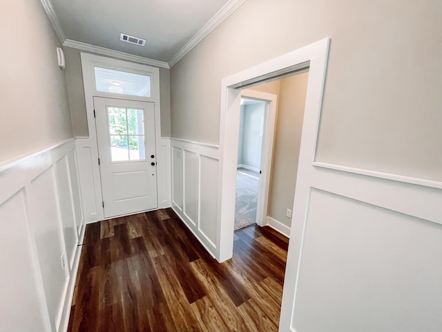doorway to outside featuring a wainscoted wall, visible vents, wood finished floors, a decorative wall, and ornamental molding