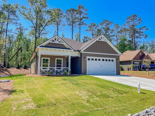 craftsman house featuring board and batten siding, an attached garage, a porch, and a front yard