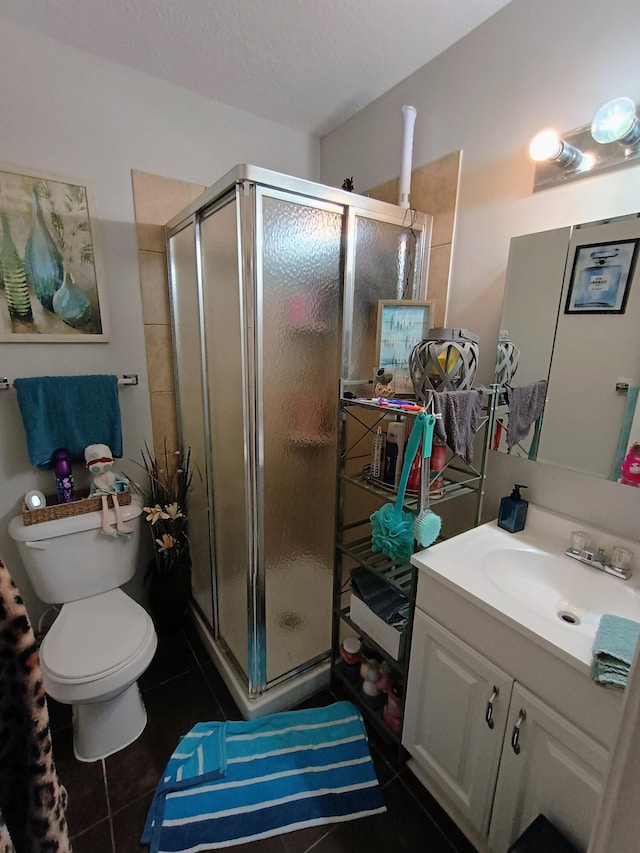 full bathroom featuring tile patterned floors, toilet, a stall shower, and vanity