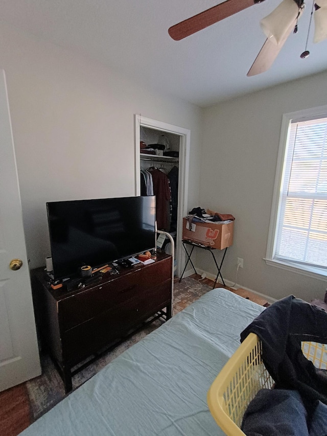 bedroom with a closet, baseboards, and a ceiling fan