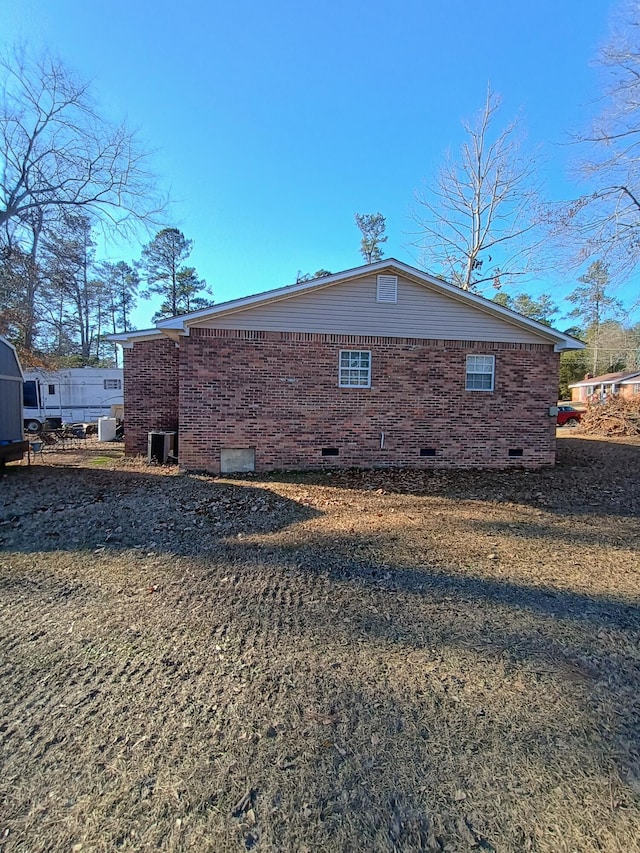 view of home's exterior featuring crawl space, brick siding, and central AC unit