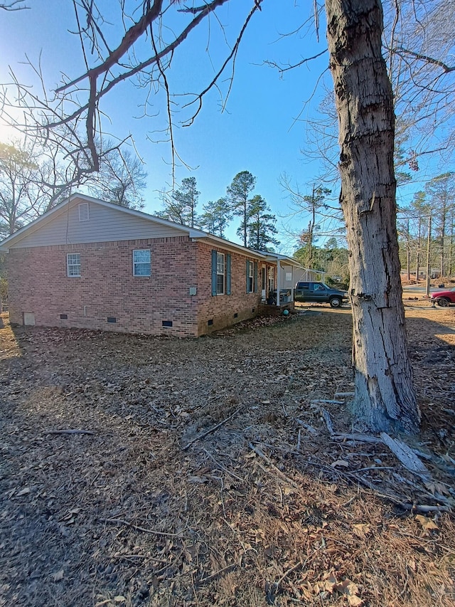 view of home's exterior with brick siding and crawl space