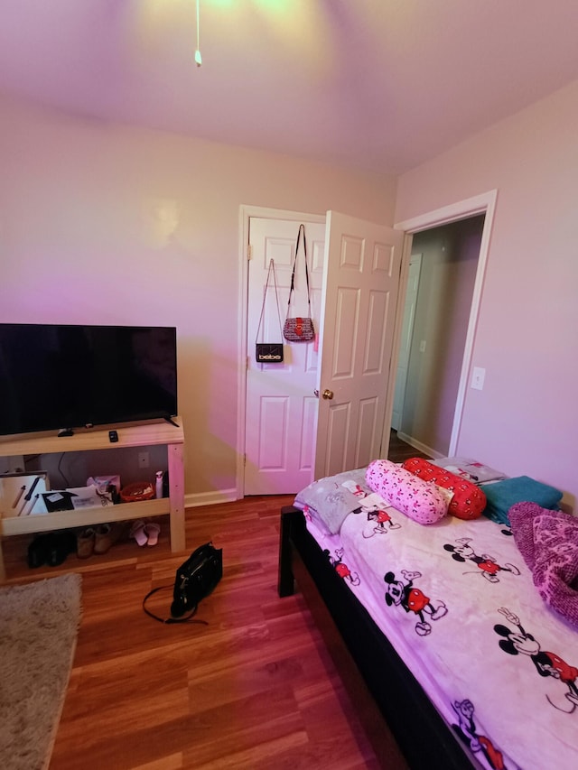 bedroom with baseboards and wood finished floors