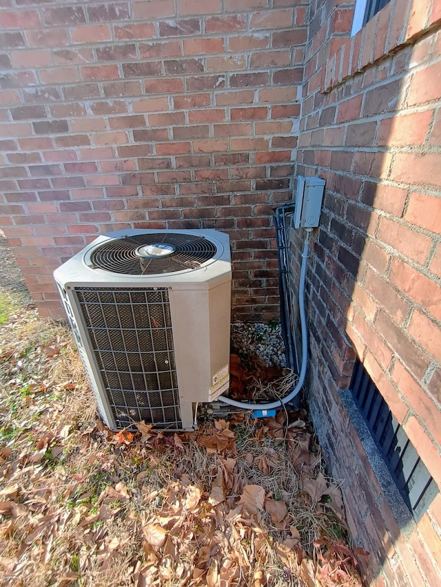 details featuring central AC unit and brick siding