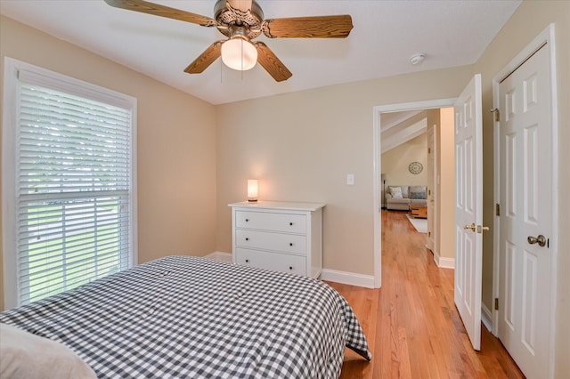bedroom with baseboards, a ceiling fan, a closet, and light wood-type flooring
