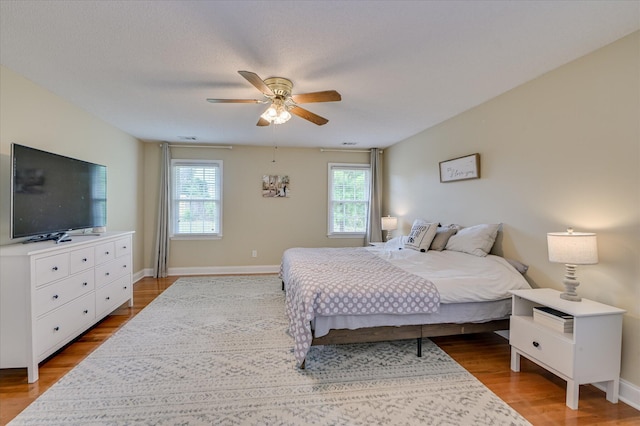 bedroom featuring baseboards, ceiling fan, and wood finished floors