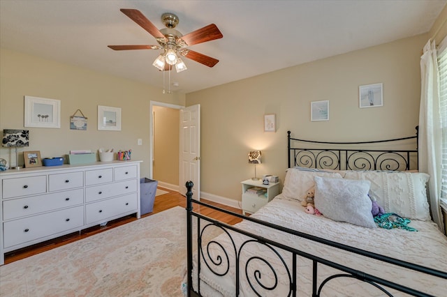 bedroom with baseboards, ceiling fan, and wood finished floors
