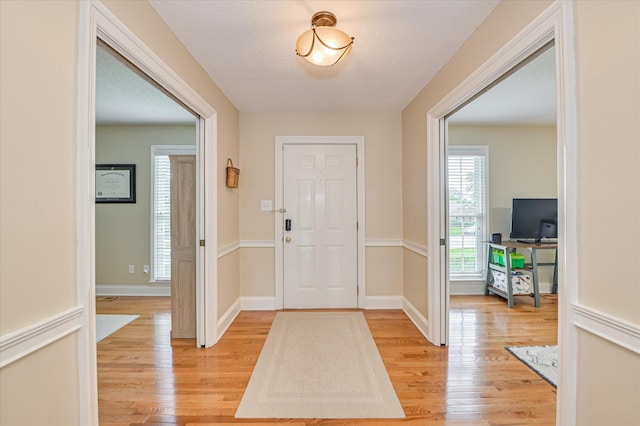 foyer featuring baseboards and light wood-style floors