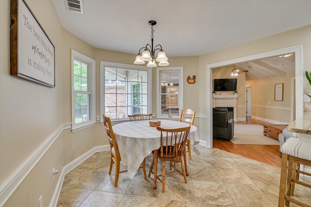 dining room with baseboards, stone finish flooring, visible vents, and a fireplace