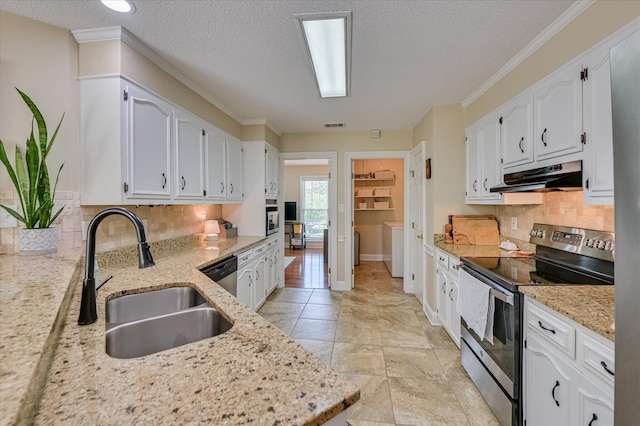 kitchen with white cabinetry, under cabinet range hood, light stone counters, a sink, and appliances with stainless steel finishes