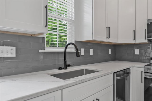 1017 Miller St, Augusta, GA 30901 - kitchen with a sink, white cabinets, backsplash, and appliances with stainless steel finishes