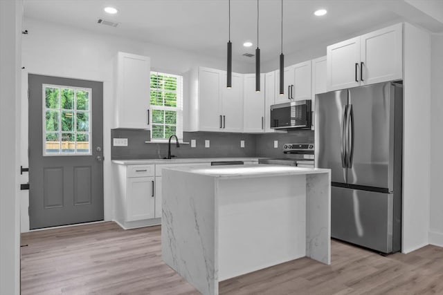 1017 Miller St, Augusta, GA 30901 - kitchen with appliances with stainless steel finishes, white cabinets, backsplash, light wood-type flooring, and recessed lighting
