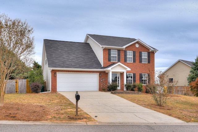 colonial-style house featuring a front yard and a garage