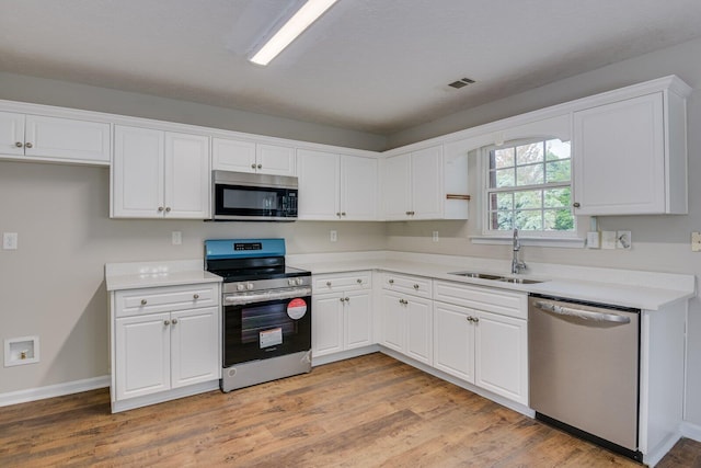 kitchen featuring white cabinets, sink, light wood-type flooring, and stainless steel appliances