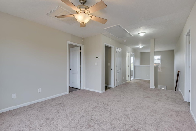 spare room featuring light carpet, ceiling fan, and a textured ceiling