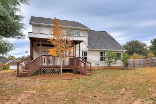 back of property with a yard and a deck