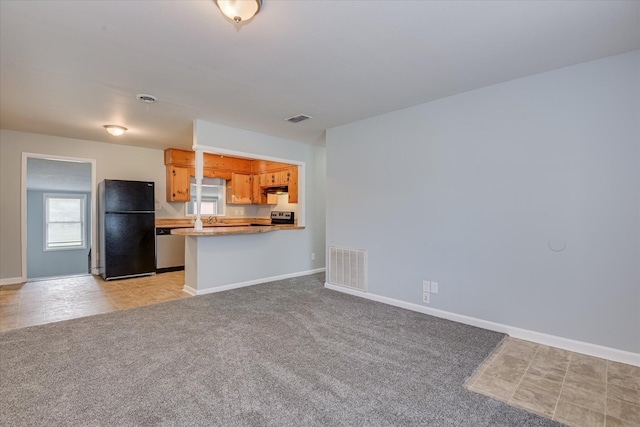 2009 Brighton Cir, Augusta, GA 30906 - kitchen with freestanding refrigerator, stainless steel electric range, under cabinet range hood, light colored carpet, and open floor plan