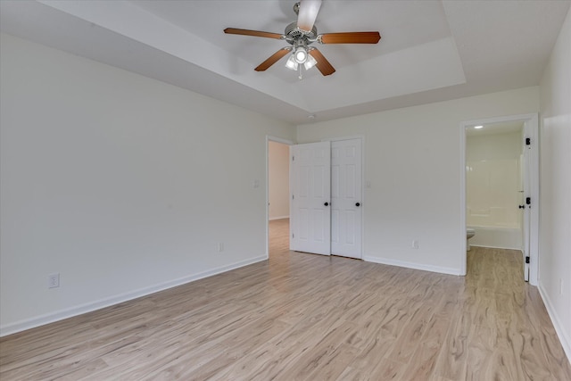 1532 Abby Way, Augusta, GA 30909 - unfurnished bedroom featuring a tray ceiling, light wood-style floors, connected bathroom, and a ceiling fan