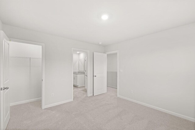 unfurnished bedroom featuring light carpet and a closet