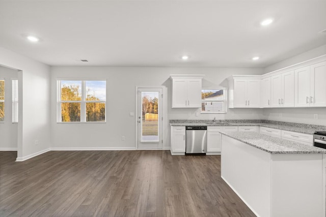 kitchen with white cabinets, dark hardwood / wood-style floors, stainless steel dishwasher, and light stone counters