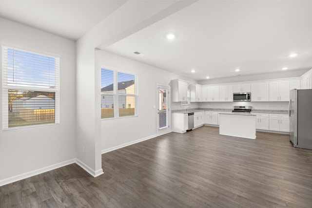 kitchen featuring appliances with stainless steel finishes, a center island, dark hardwood / wood-style floors, and white cabinetry