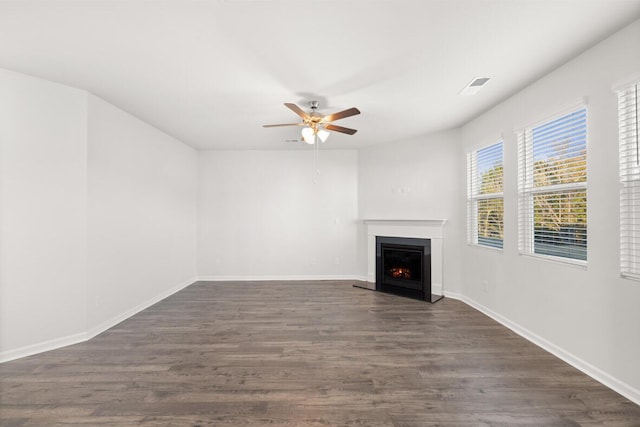 unfurnished living room featuring ceiling fan and dark wood-type flooring