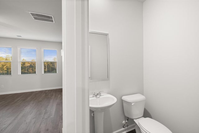 bathroom with hardwood / wood-style floors and toilet