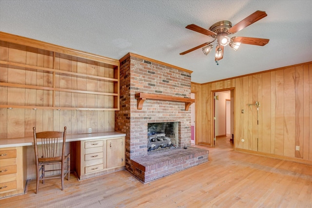 413 Mcintosh Dr, Waynesboro, GA 30830 - unfurnished living room with crown molding, a ceiling fan, wood finished floors, wooden walls, and a fireplace