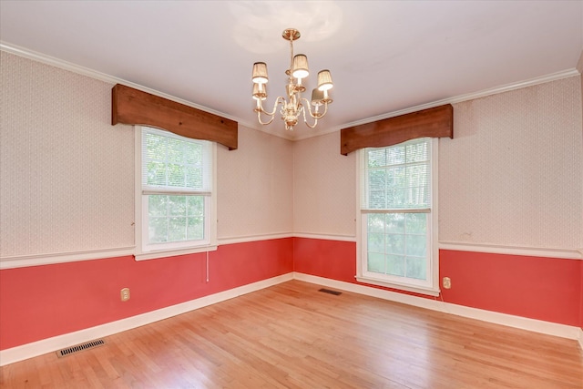 413 Mcintosh Dr, Waynesboro, GA 30830 - unfurnished room with crown molding, a chandelier, wood finished floors, plenty of natural light, and wallpapered walls