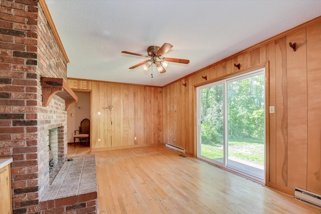 413 Mcintosh Dr, Waynesboro, GA 30830 - unfurnished living room featuring a baseboard radiator, light wood-type flooring, a baseboard heating unit, ornamental molding, and a ceiling fan