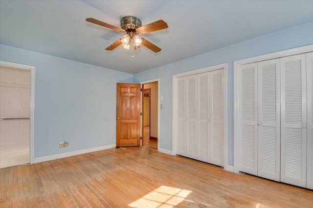 413 Mcintosh Dr, Waynesboro, GA 30830 - unfurnished bedroom with two closets, wood finished floors, baseboards, and ceiling fan