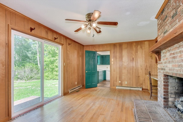413 Mcintosh Dr, Waynesboro, GA 30830 - unfurnished living room with a baseboard radiator, a ceiling fan, a fireplace, light wood-style flooring, and wooden walls