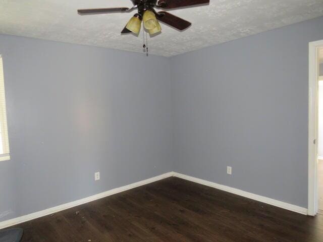 spare room with dark wood-style flooring, ceiling fan, a textured ceiling, and baseboards