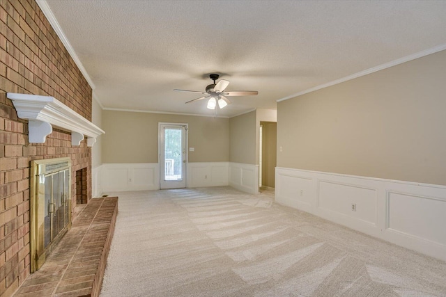 unfurnished living room with ceiling fan, crown molding, a textured ceiling, a fireplace, and carpet