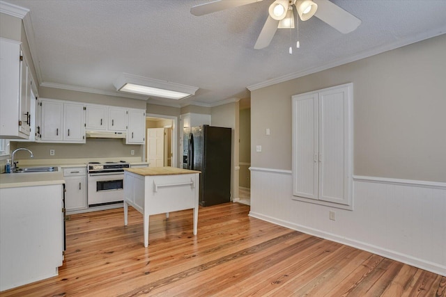 kitchen with white range with electric cooktop, white cabinets, black fridge, sink, and ornamental molding