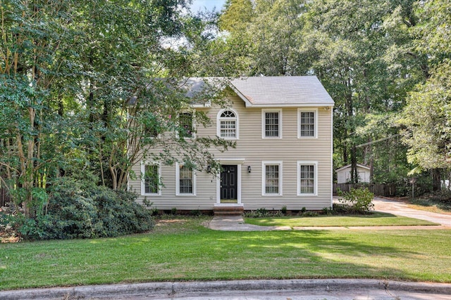 colonial inspired home featuring a front lawn