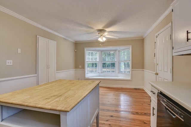 kitchen featuring dishwasher, light hardwood / wood-style flooring, ceiling fan, and crown molding