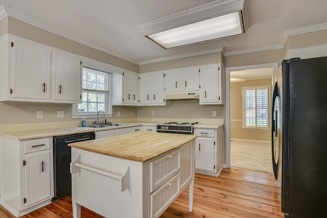 kitchen with white cabinets, sink, a kitchen island, and black appliances