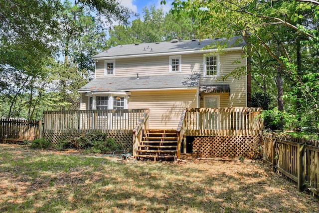 rear view of property featuring a yard and a deck