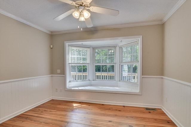 spare room with crown molding, ceiling fan, and a healthy amount of sunlight