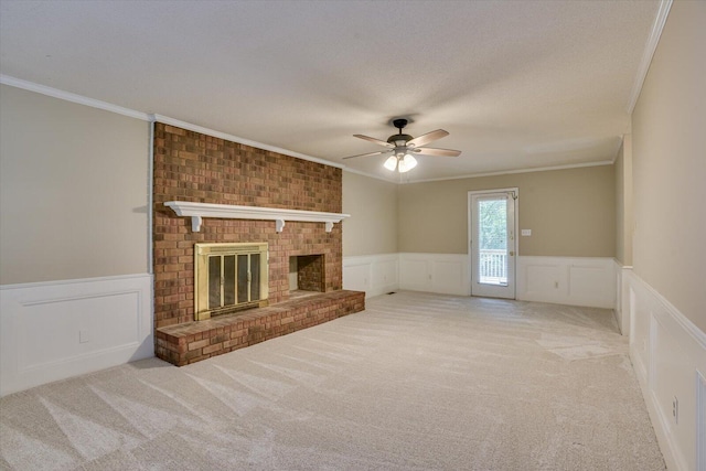 unfurnished living room with a fireplace, light carpet, ceiling fan, and crown molding