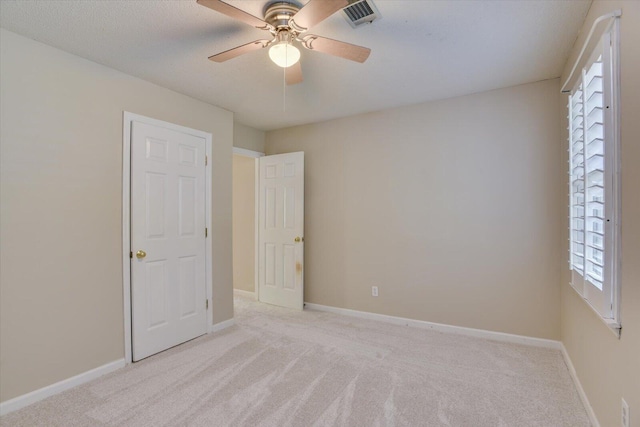 unfurnished room featuring light colored carpet and ceiling fan