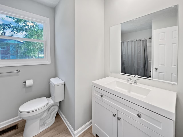 bathroom featuring a shower with curtain, vanity, wood-type flooring, and toilet